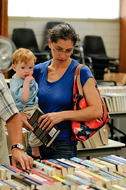 Woman with child browsing books at Friends sale