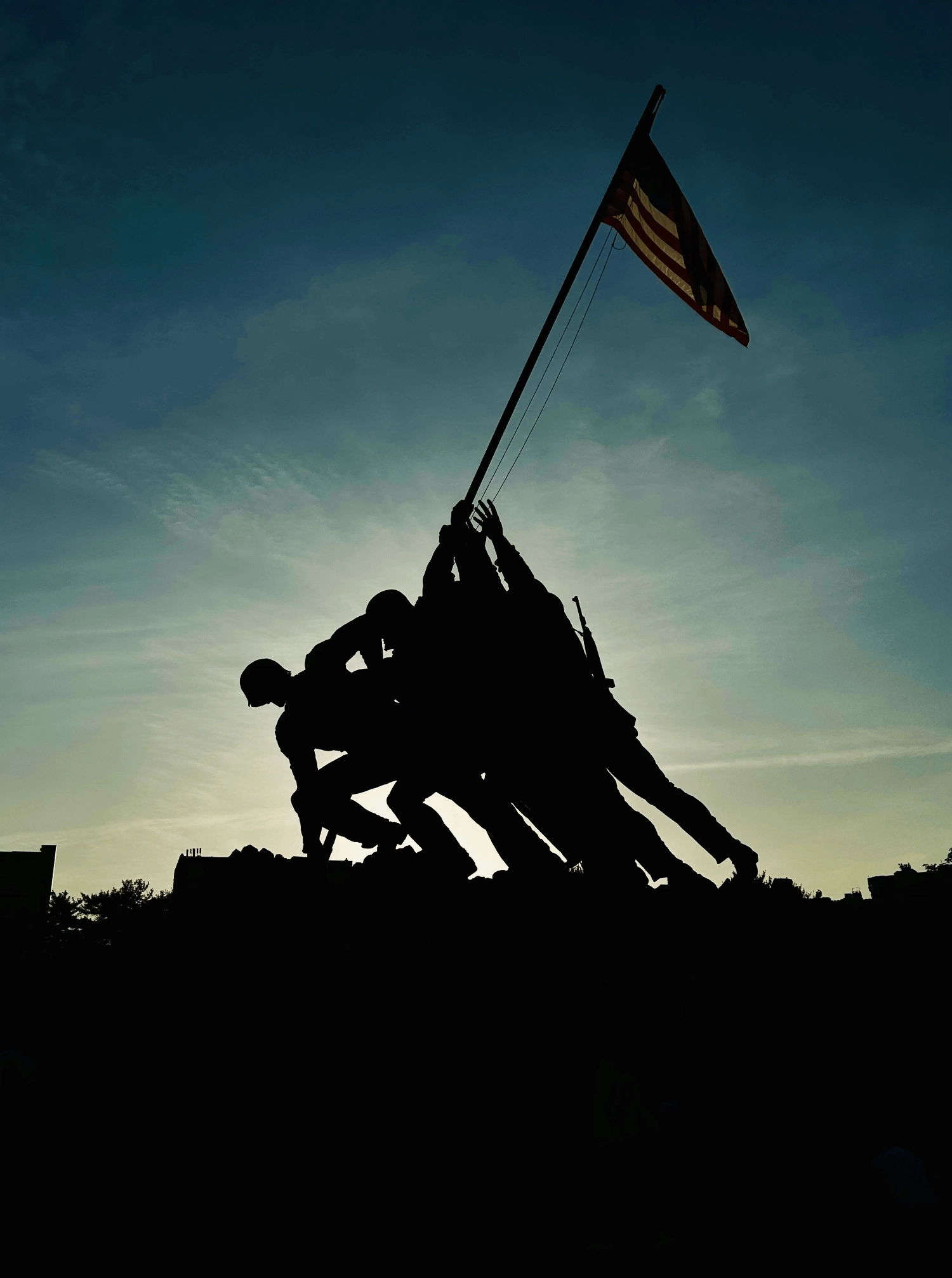 Outline of the Iwo Jima Memorial statue against a twilight sky.